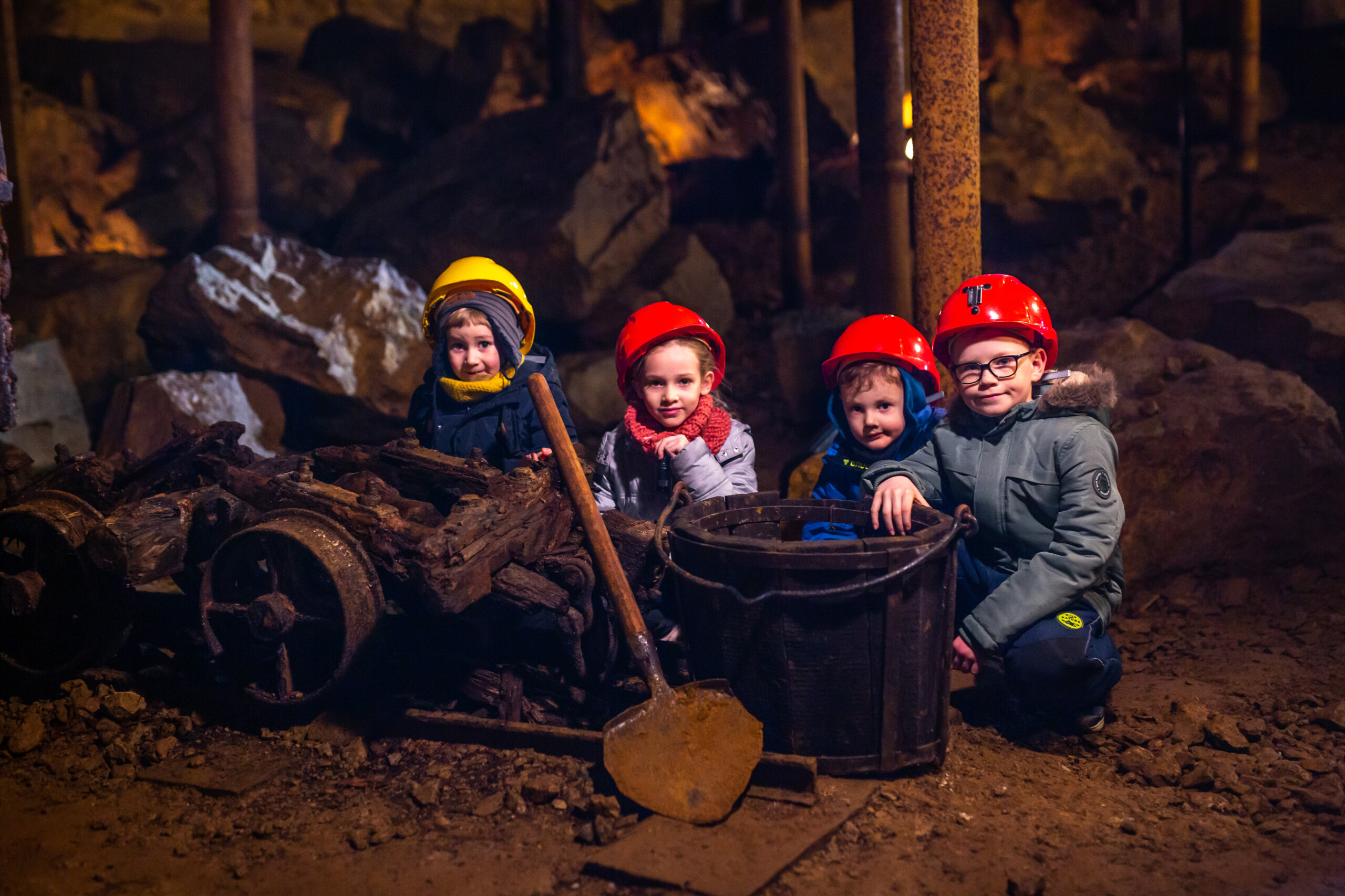 Dzieci kucające przy wózku transportowym w podziemiach