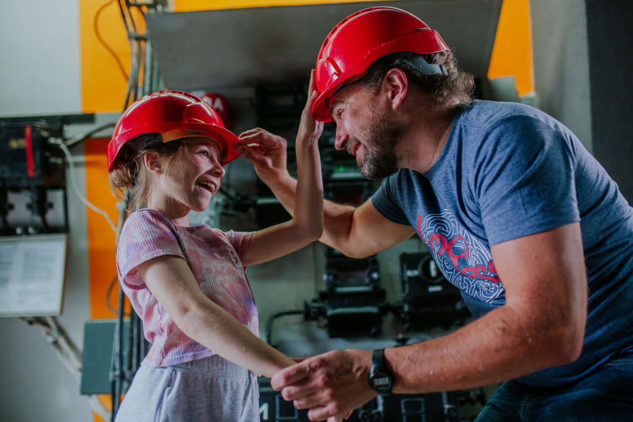 Mężczyzna i dziecko zakładają czerwone kaski