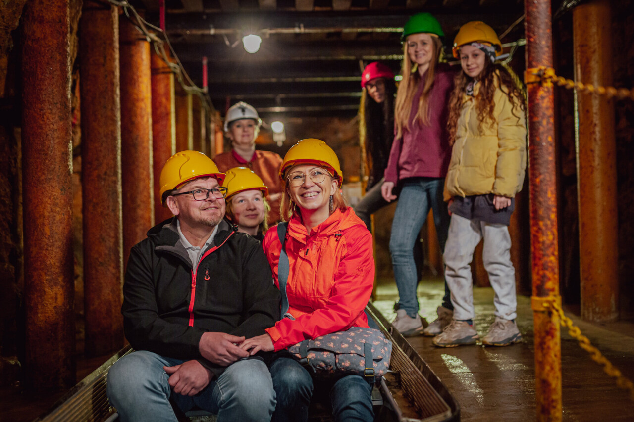 Turyści w żółtych kaskach wsiadający do łodzi