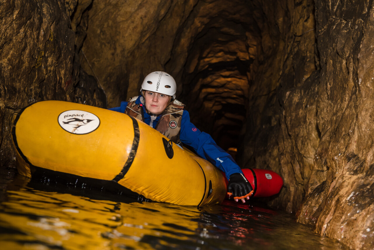Kobieta w białym kasku siedzi w żółtym pontonie