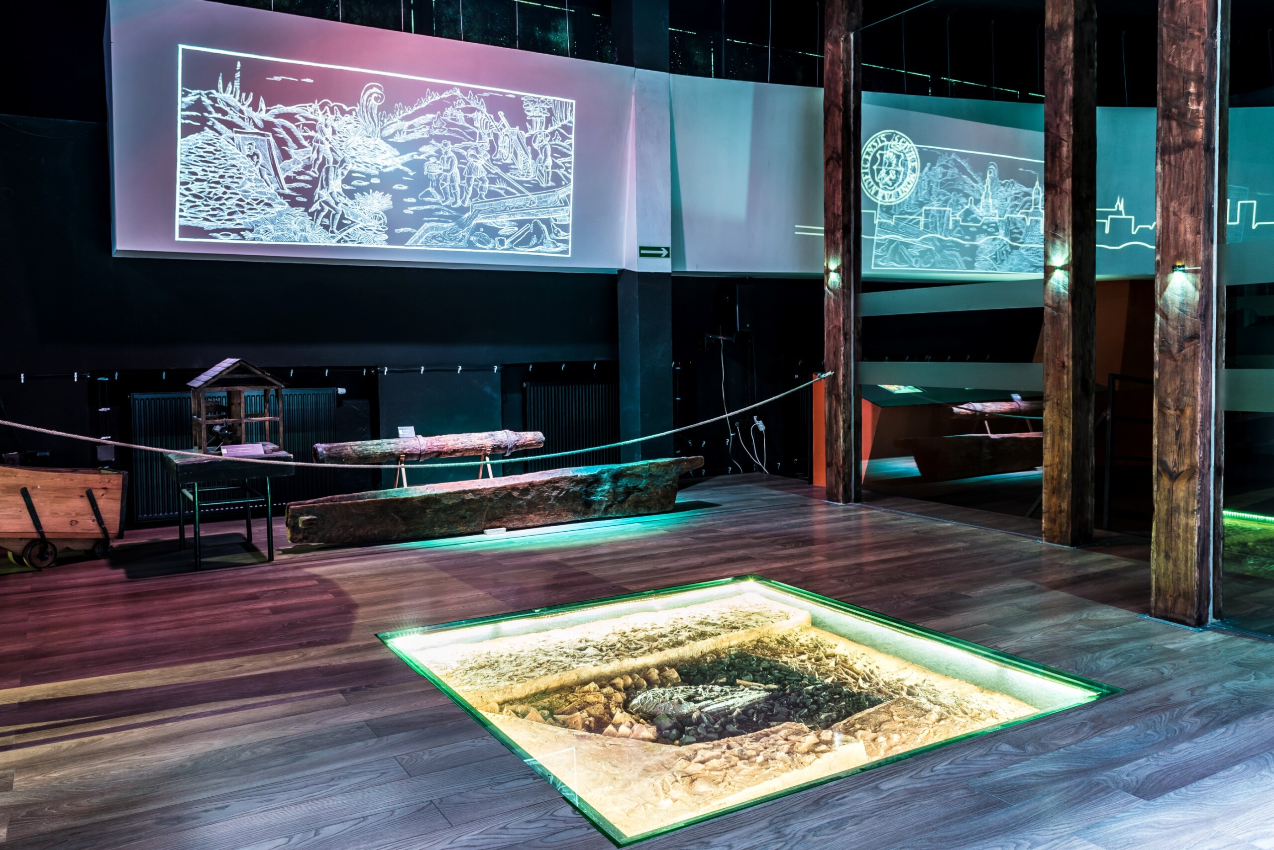 Sala muzealna z podświetlonym, przeszklonym modelem pieca w podłodze