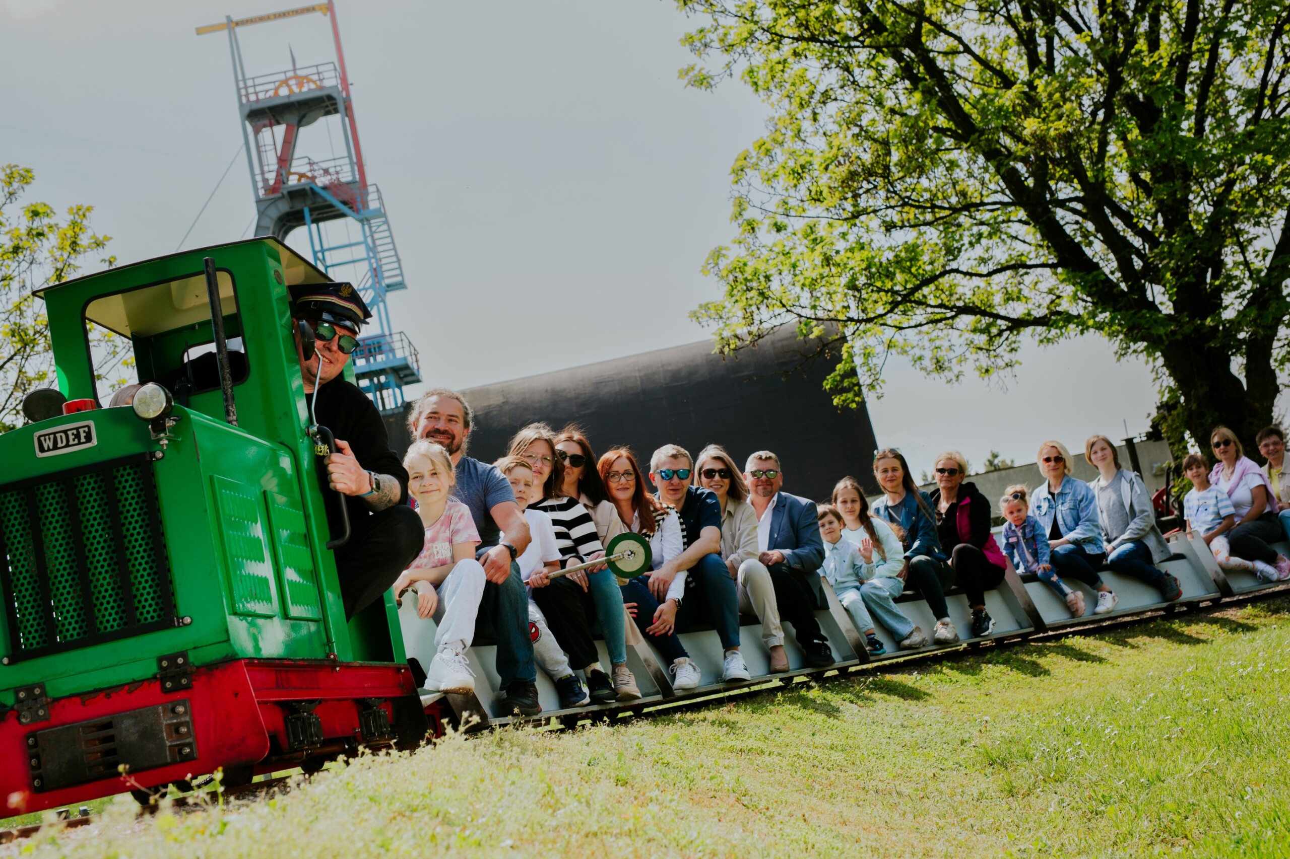 Ludzie jadący kolejką w Skansenie Maszyn Parowych