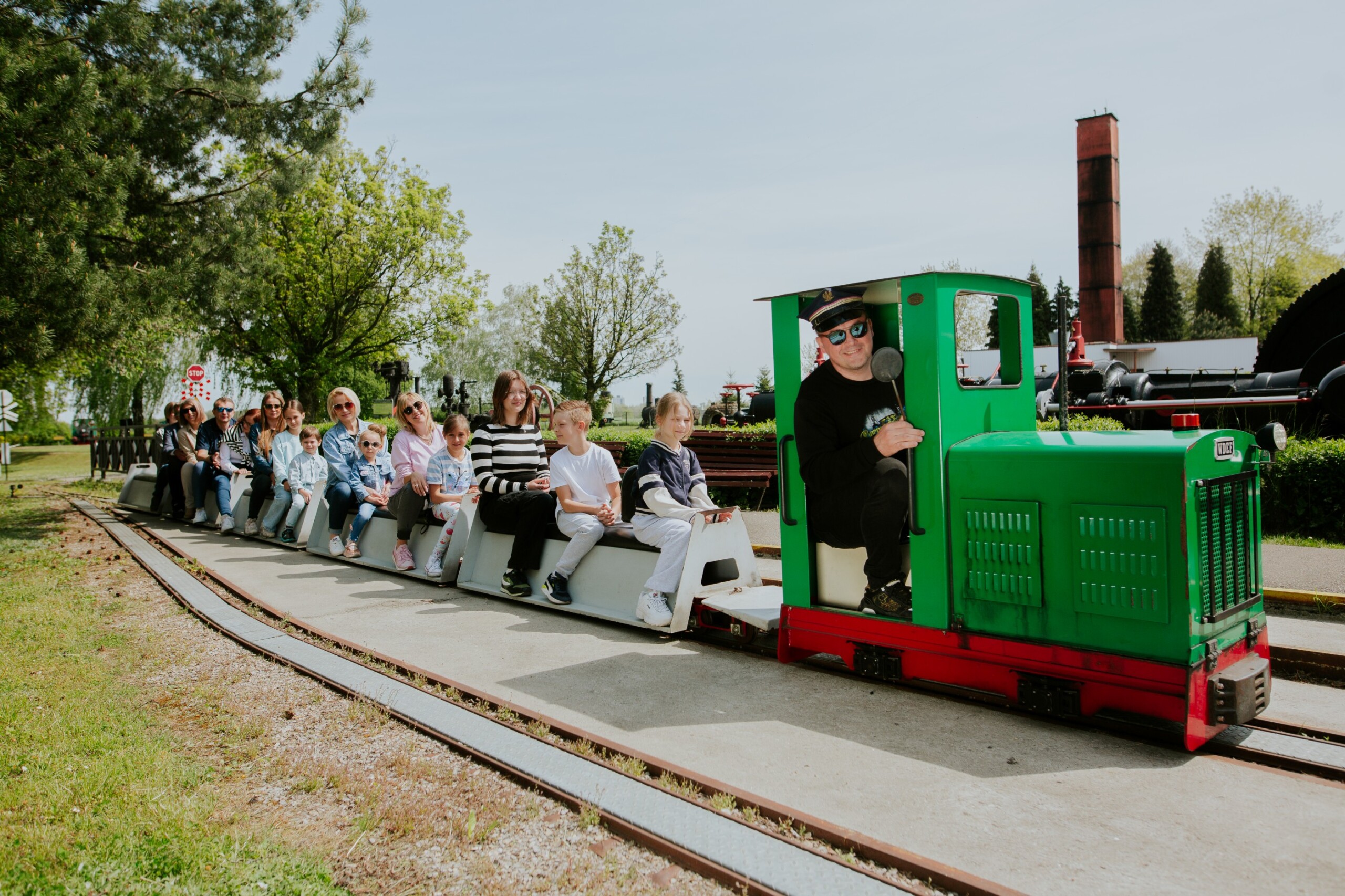 Ludzie jadący kolejką w Skansenie Maszyn Parowych