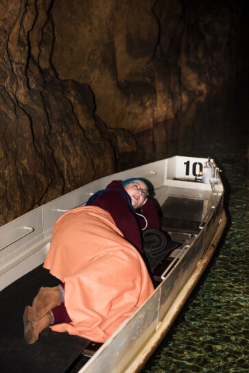 kobieta leży w łodzi płynącej w sztolni