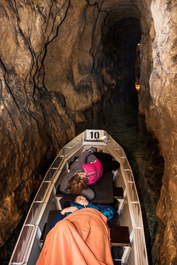 dwie osoby płynące łodzią w sztolni