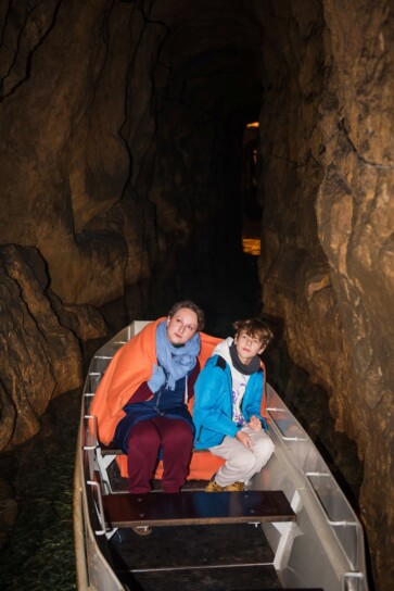 dwie osoby płynące łodzią w sztolni