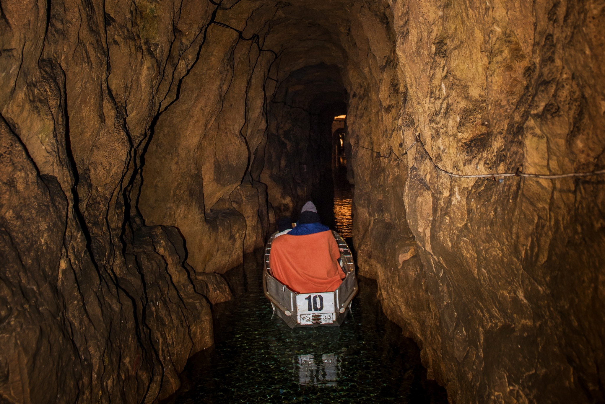 dwie osoby płynące łodzią w sztolni